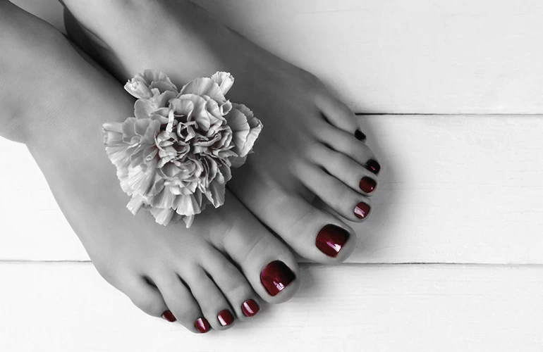 Kobieta z czerwonymi paznokciami u stóp
